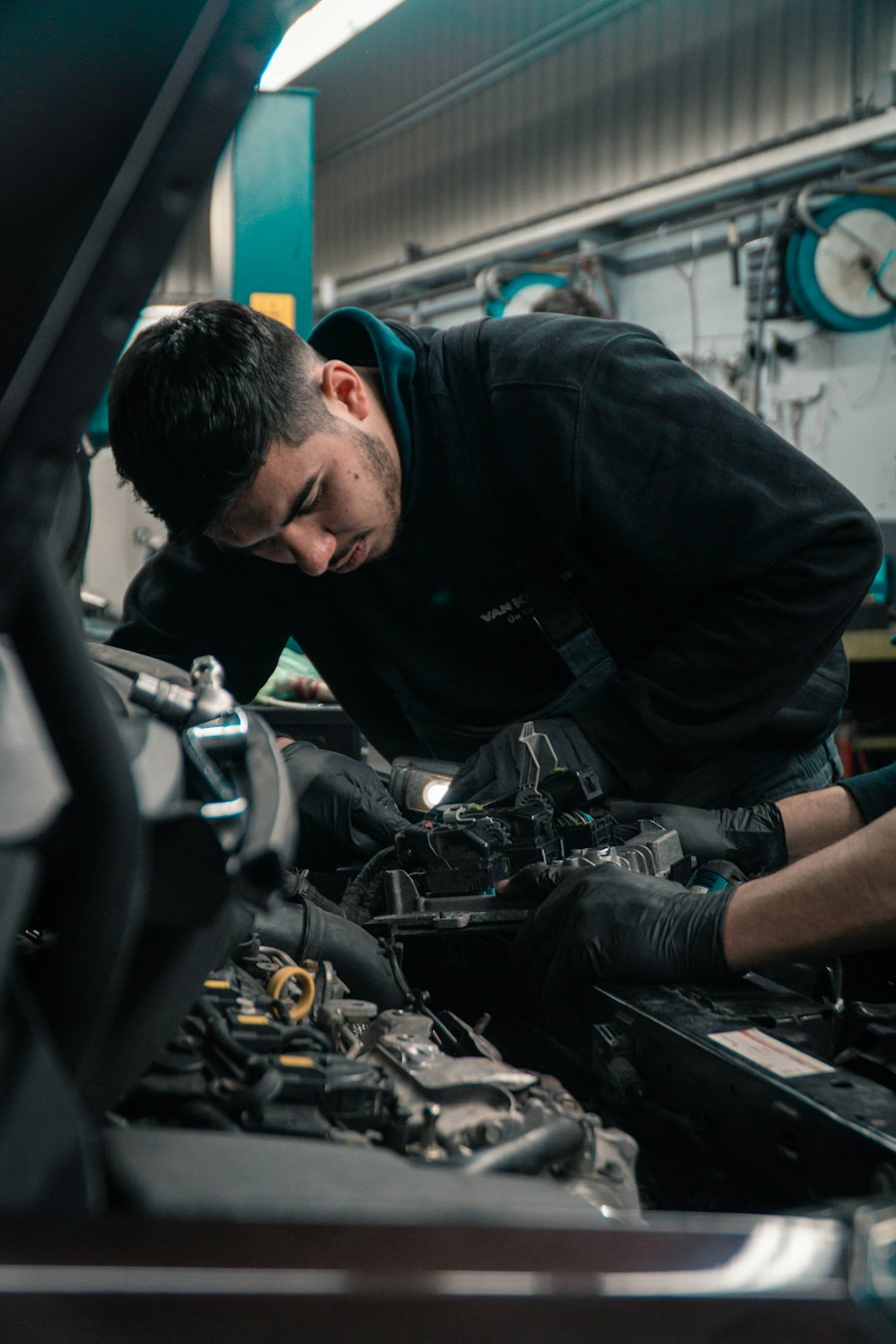 A mechanic working under the hood of a car